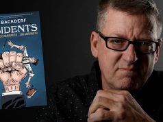 DC – The Dissidents Signing | Sept 10th A man with glasses sits in a dark room beside a floating book titled “The Dissidents: Autocrats, Voltaires, Commanders, and Commandos” by Derf Backderf.